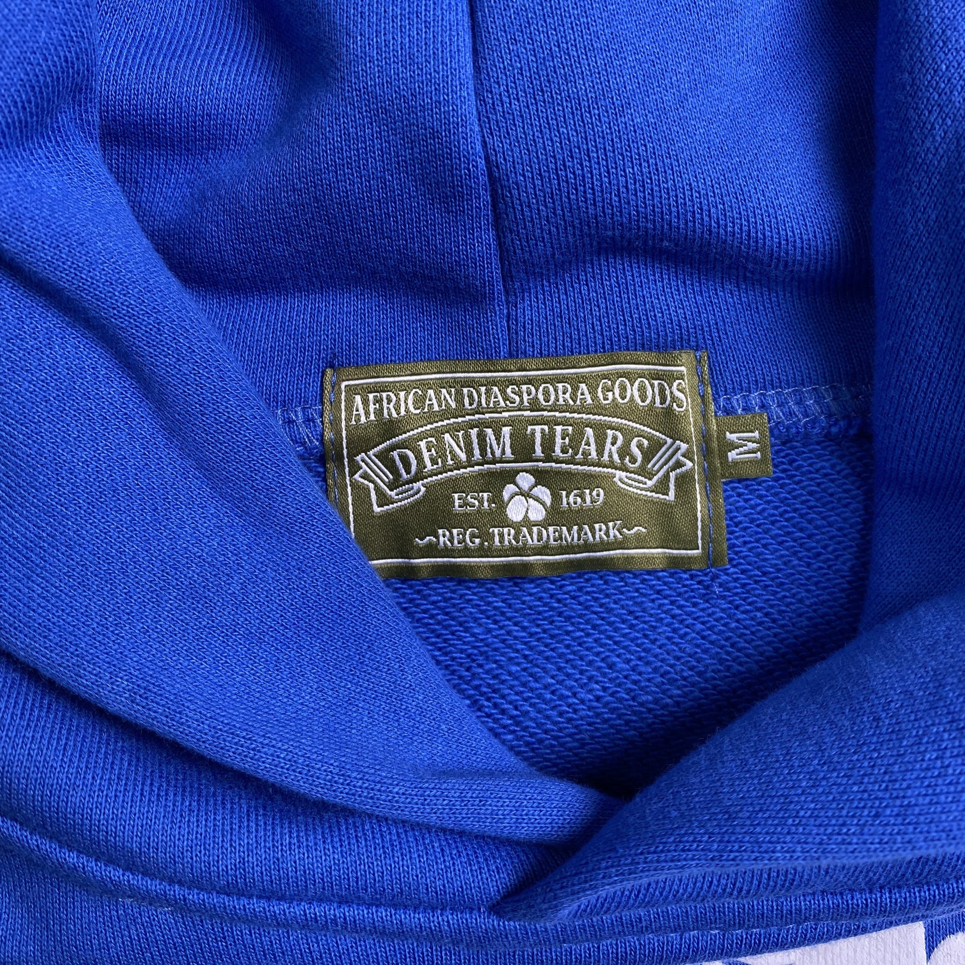 denim-tears-the-cotton-wreath-hoodie-royal-blue-3-Drip Store Argentina